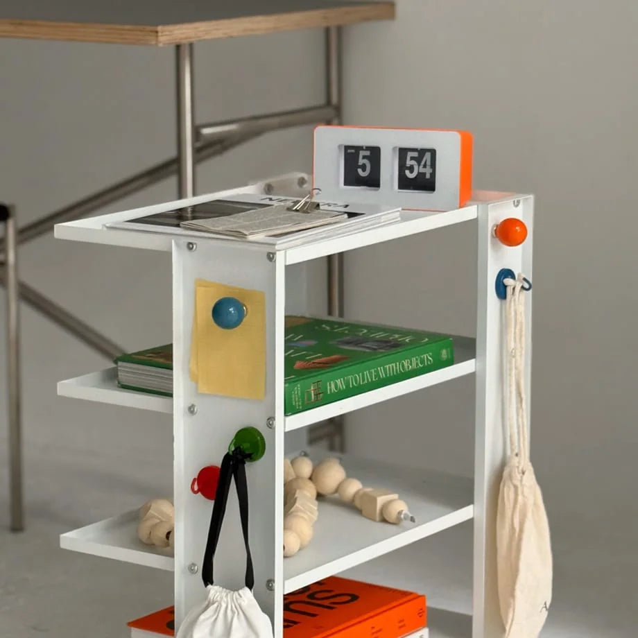 Multiple colorful magnetic hooks organizing items on a white multi-level shelf. - RoomDen