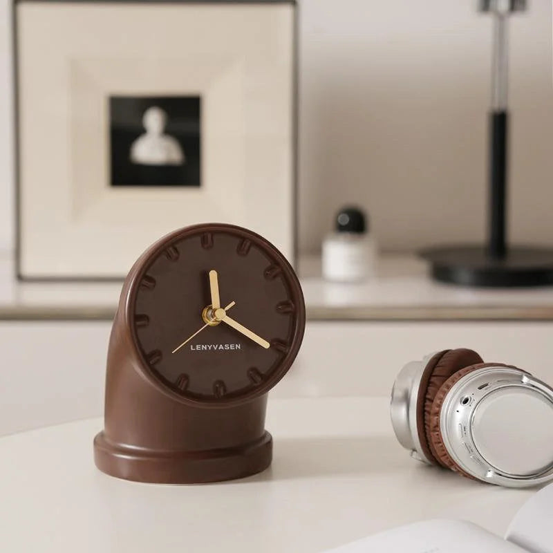 Mocha brown Industrial Pipe Ceramic Table Clock on a desk with headphones and decor in the background - RoomDen