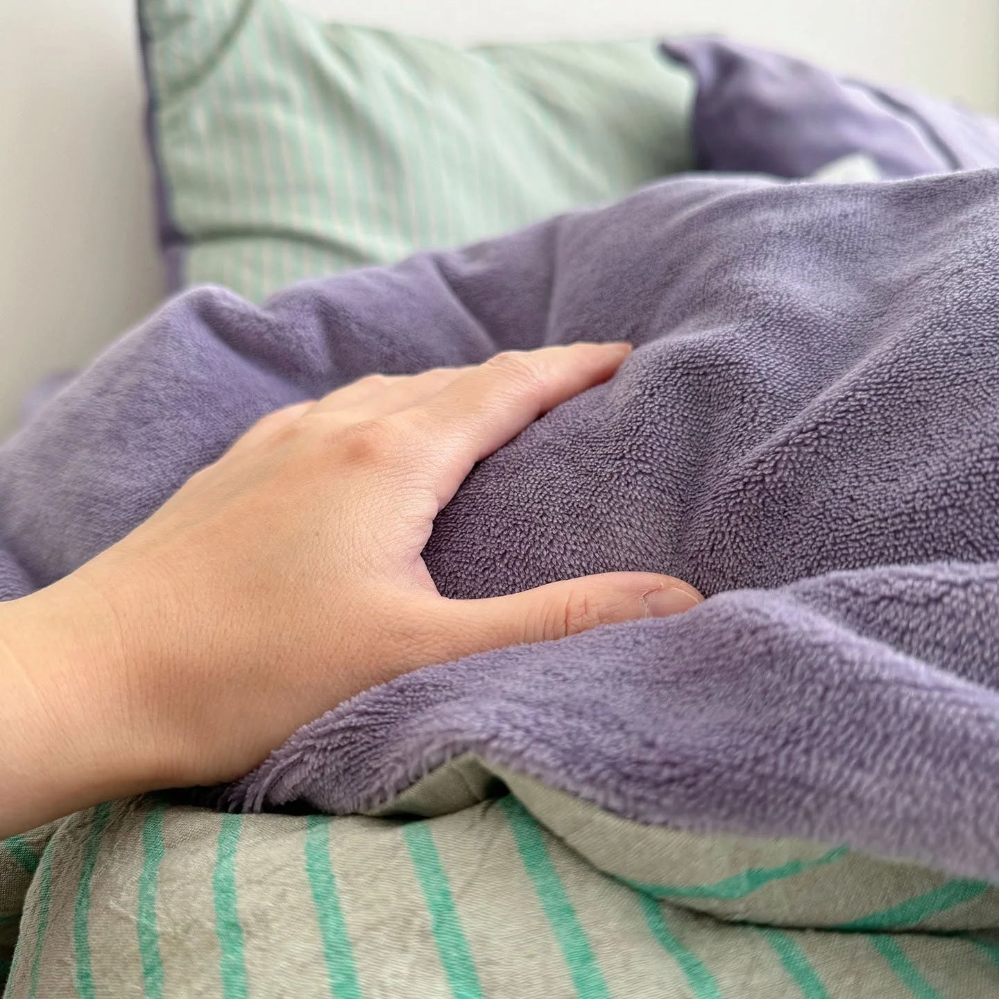 Close-up detail shot of the soft purple flannel fleece texture of the reversible bedding set.