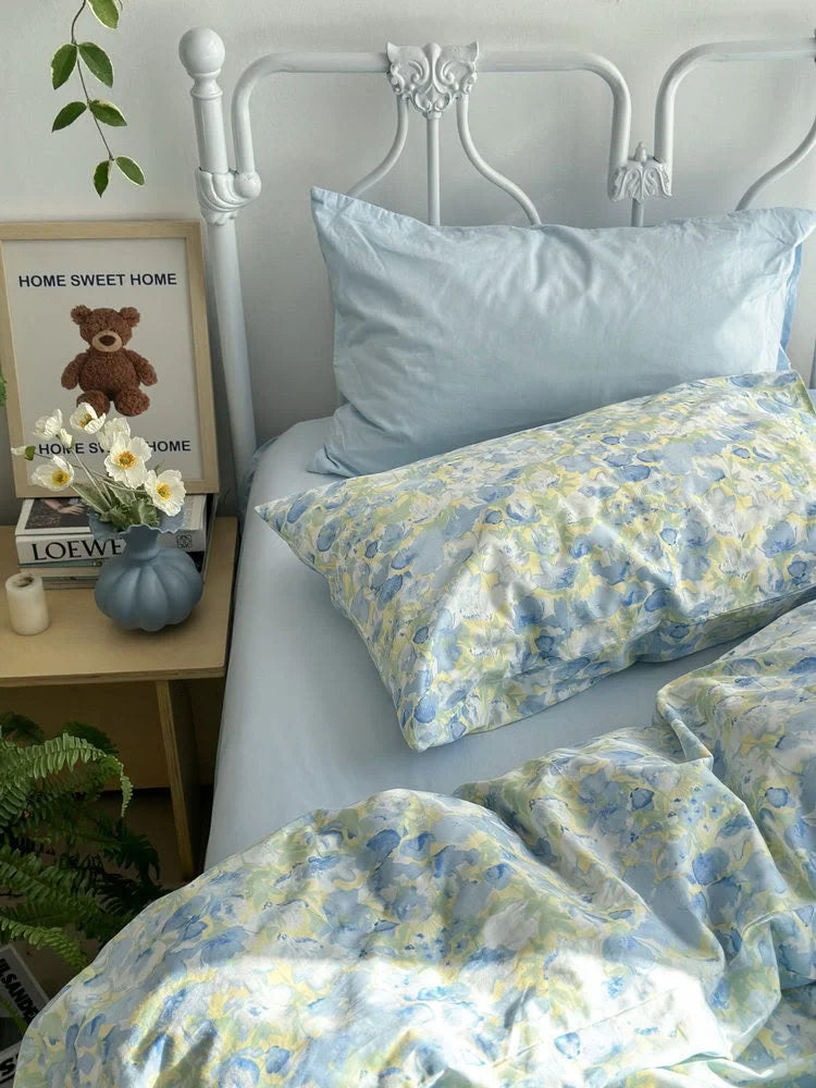 Side view showing the floral pillowcase and duvet cover against a white wall with climbing plants. - RoomDen