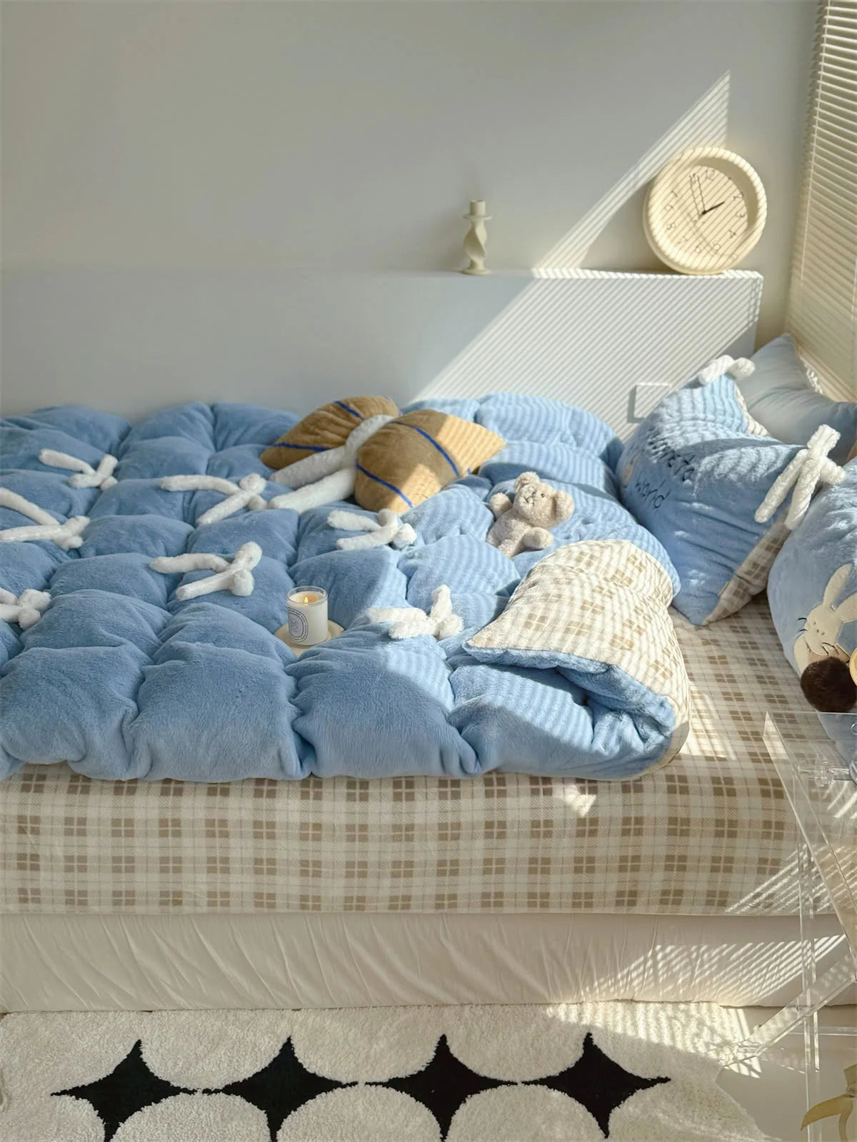 Full view of the Baby Blue Bunny bedding set on a bed with a gingham sheet, showing the overall room aesthetic.