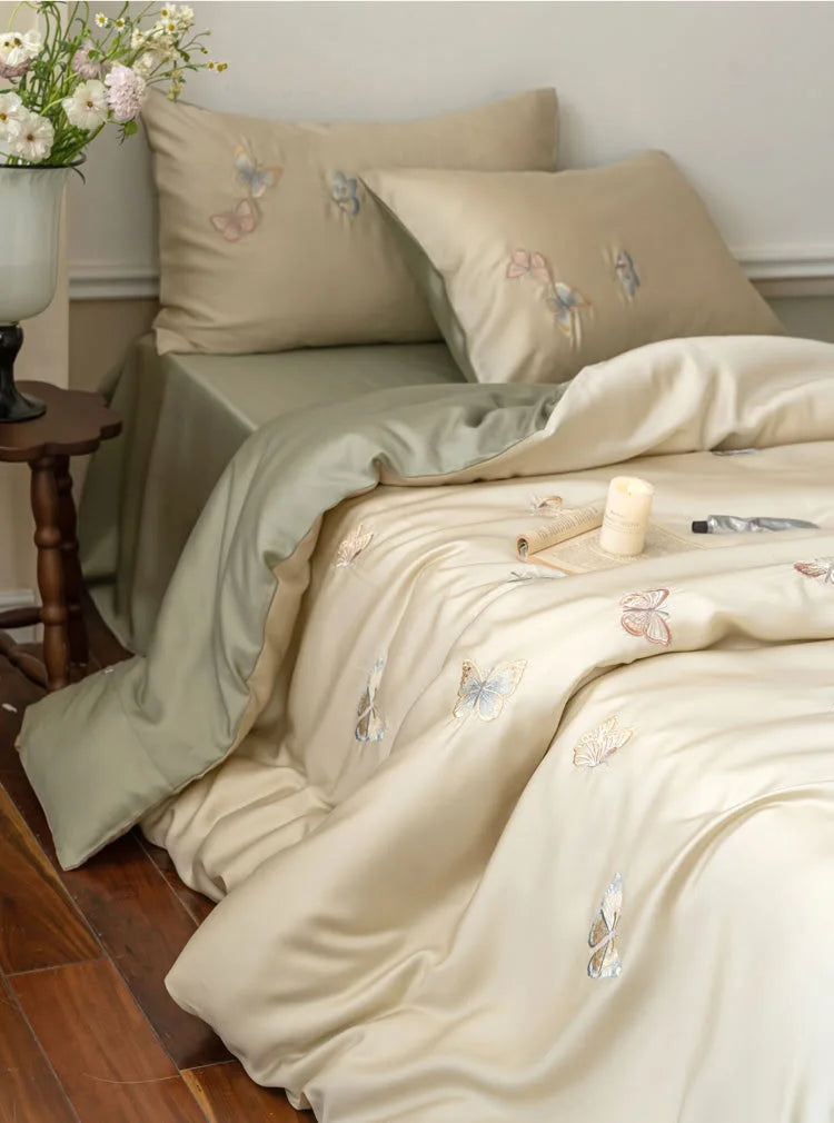 Silky Butterfly Embroidered Tencel Bedding Set in beige and sage green, close-up on pillowcases - RoomDen