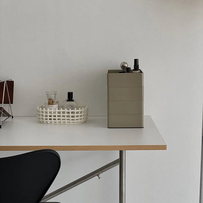 Sleek Minimalist ABS Rotating Makeup Organizer in Khaki Grey, styled on a modern white and wood desk.