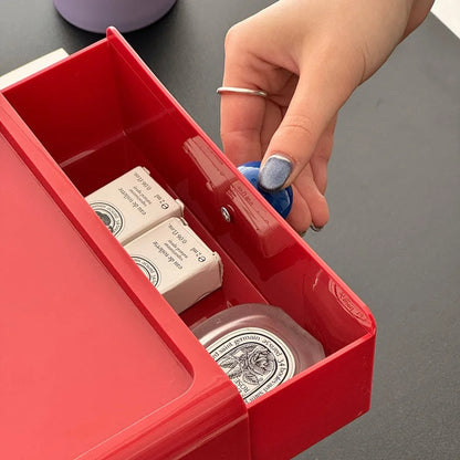 The red desk drawer opened to show small cosmetic items stored inside, highlighting its versatility. - RoomDen
