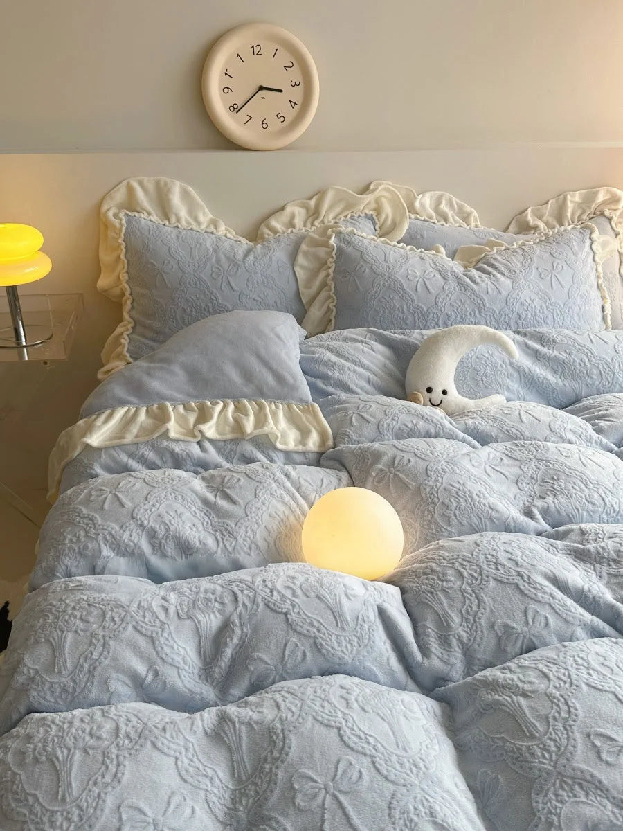 Close-up of the Powder Blue pillowcases and duvet cover, highlighting the detailed embossed pattern and ruffles - RoomDen.