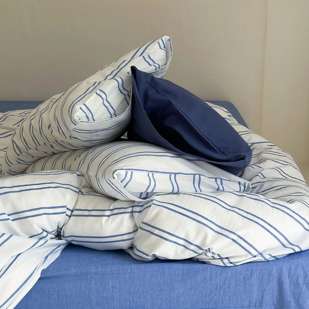 Stack of Striped and Solid Blue Pillows and Duvet - Material Detail