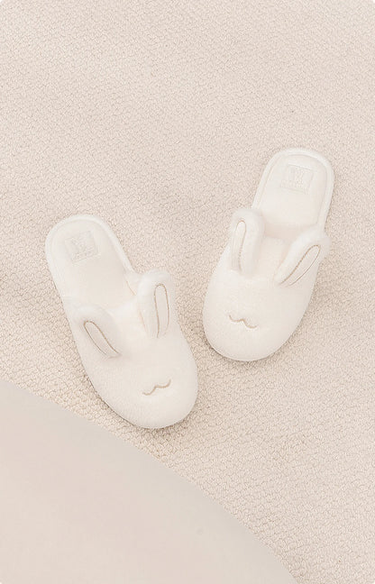 Top view of white bunny slippers showing embroidered face details - RoomDen