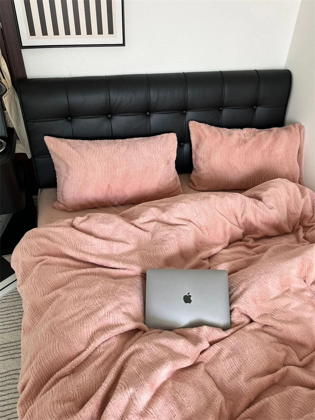 Full view of the Blush Pink flannel fleece bedding set on a bed with a black headboard, showing its plush texture. - RoomDen