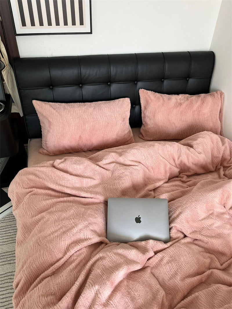 Full view of the Blush Pink ruched fleece bedding set on a bed with a black headboard, the muted pink reading as warm calm. - RoomDen