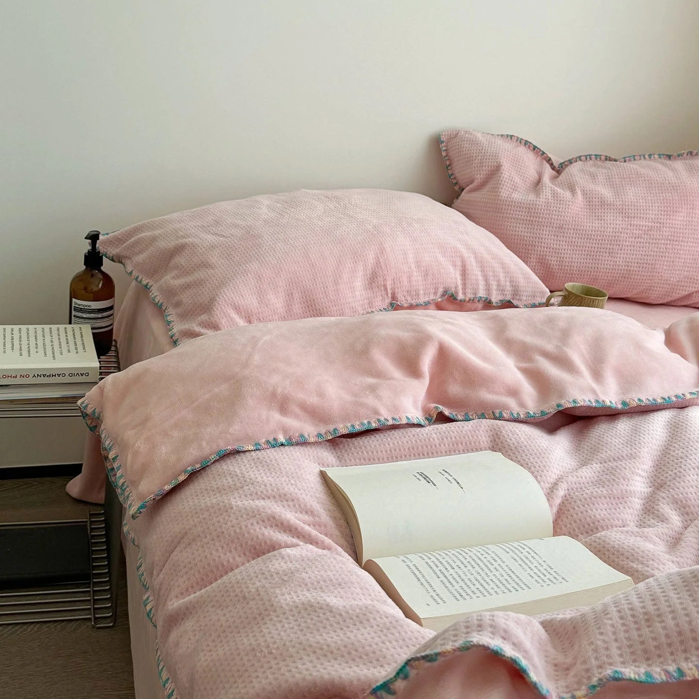 Main image of the Blush Pink Plush Waffle Fleece Bedding Set variant with an open book. - RoomDen