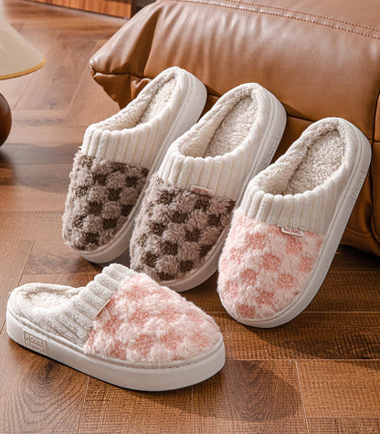 Fuzzy checkered house slippers in pink and brown on wooden floor - RoomDen