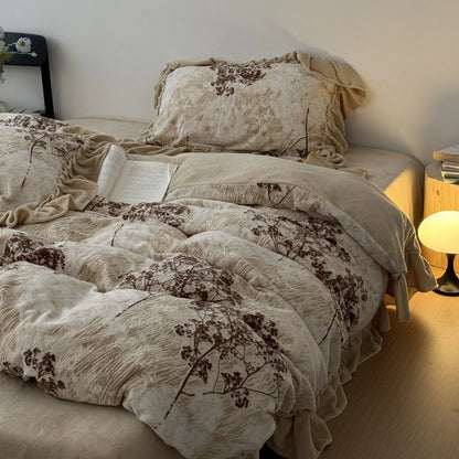 A full view of the ruffled floral branch washed cotton bedding set on a bed, with a warm lamp and an open book creating a cozy, hygge atmosphere - RoomDen.