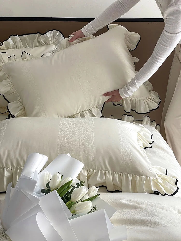 Detail shot of a person arranging the Cream White ruffled pillow, highlighting the jacquard pattern and texture - RoomDen.