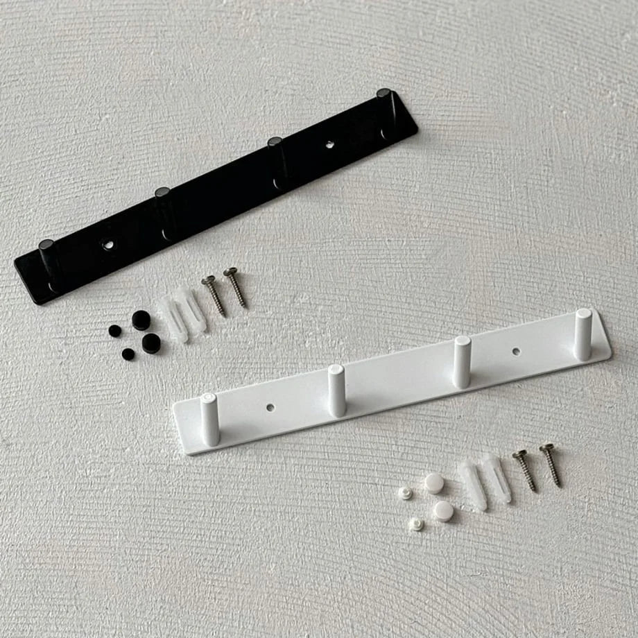 The black and white minimalist metal wall hook racks shown with included mounting hardware for drilling and adhesive options - RoomDen.