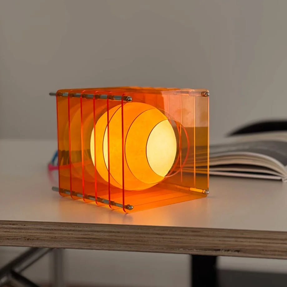 Detailed shot of the Sunset Orange Caged Sphere Lamp, highlighting its geometric acrylic frame - RoomDen