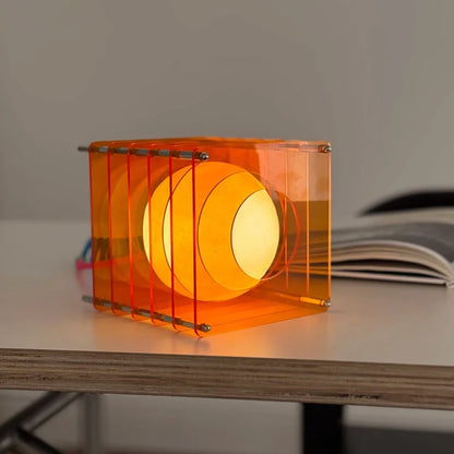 Detailed shot of the Sunset Orange Caged Sphere Lamp, highlighting its geometric acrylic frame - RoomDen