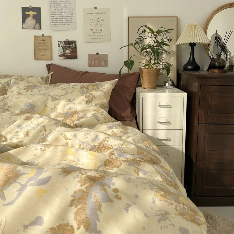 Lifestyle image of the Buttercream Floral bedding set creating a warm, sun-drenched vibe in an artistic bedroom. - RoomDen