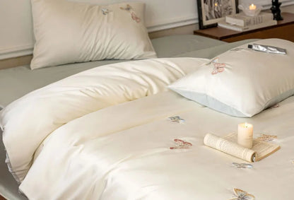 The Butterfly Embroidered Bedding Set styled with a lit candle and book, creating a cozy atmosphere.