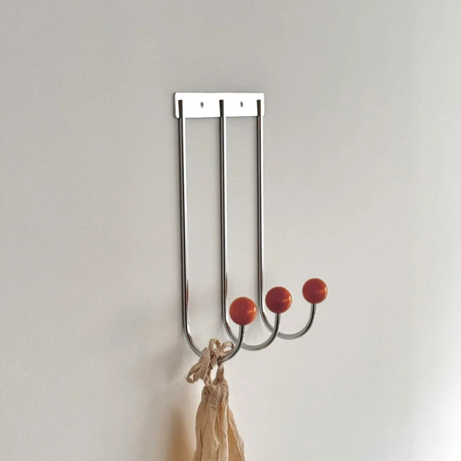 Angled close-up of the Silver & Orange Color Block Metal Wall Hooks against a plain white wall. - RoomDen