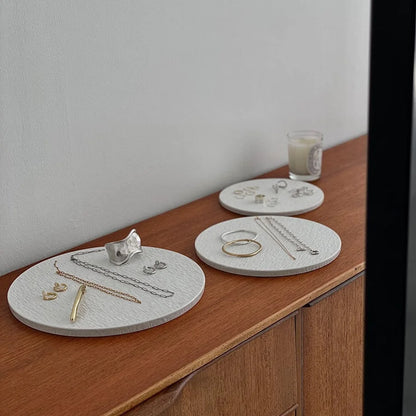 Angled shot of three textured ceramic jewelry organizers with various rings, necklaces, and earrings. - RoomDen