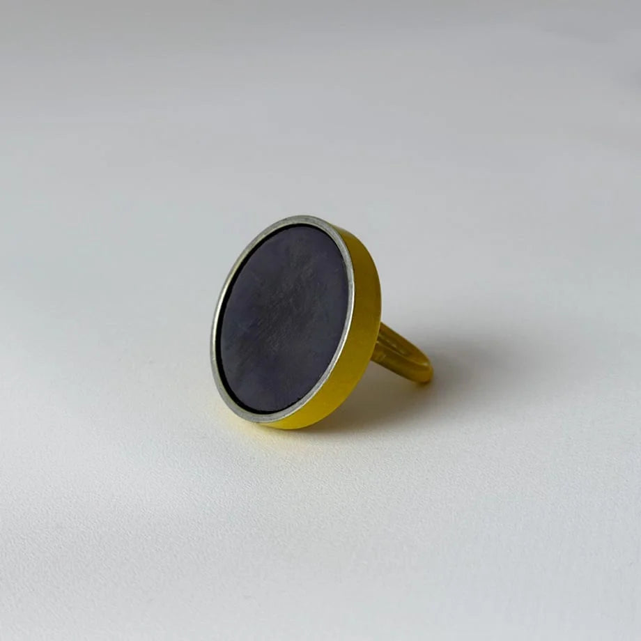 Back of the yellow magnetic hook showing the dark circular magnet attached to the base - RoomDen