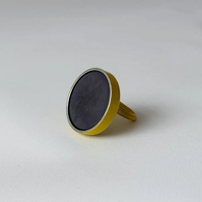 Back of the yellow magnetic hook showing the dark circular magnet attached to the base - RoomDen