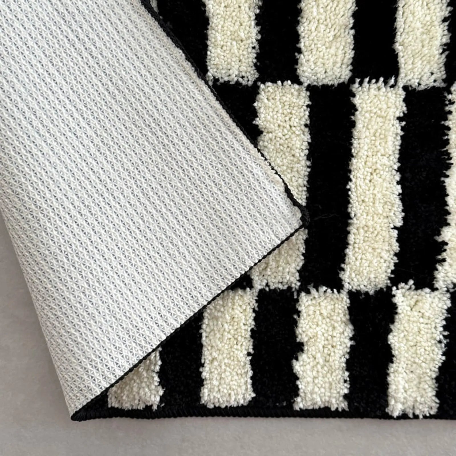 Detail shot showing the non-slip backing dots and the shaggy polyester texture - RoomDen