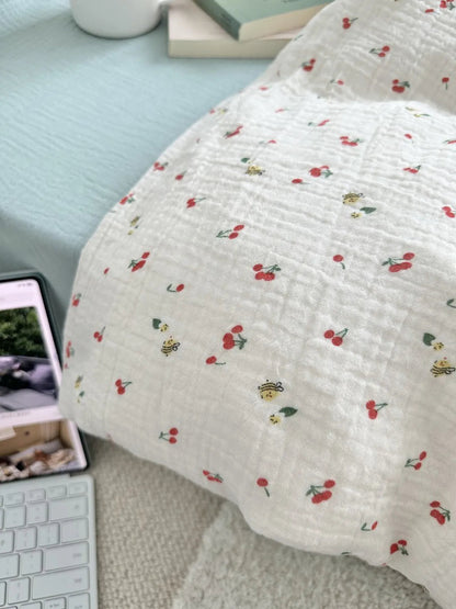 Detail shot of the crinkled texture on a pillowcase with the cherry and bee pattern. - RoomDen