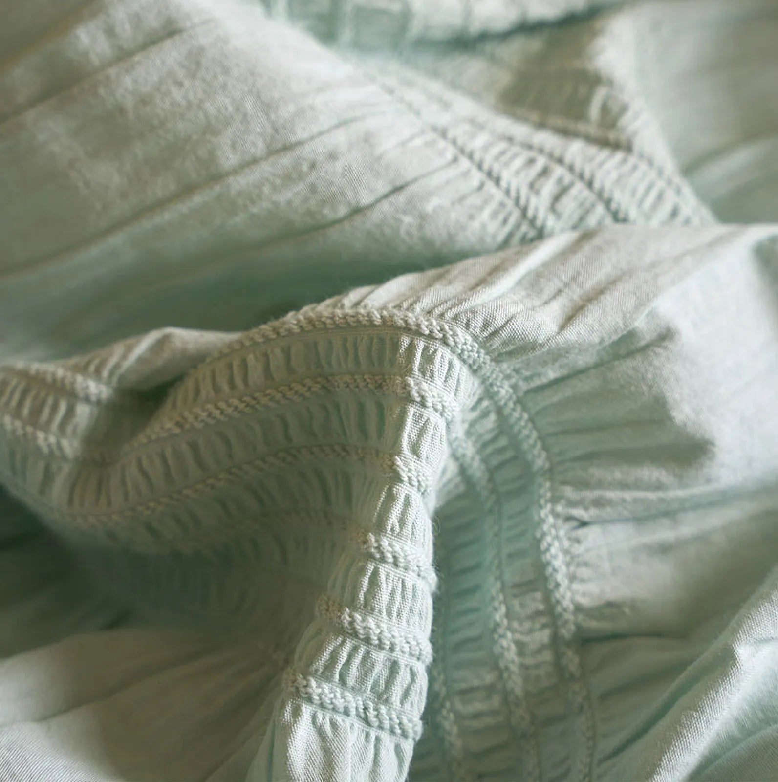 Detailed macro shot of the ruched texture on the Mint Green washed cotton fabric.