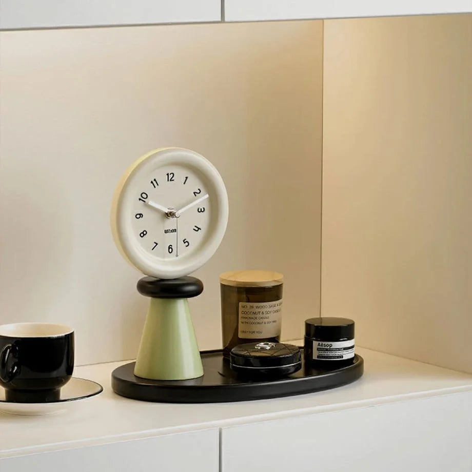 Danish Pastel green and beige wood clock with tray on a white shelf with a black mug. - RoomDen