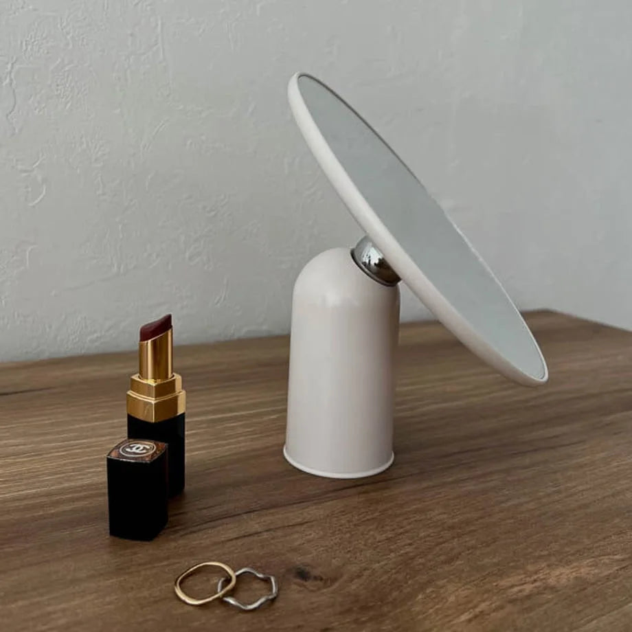 Close-up of the white rotating desktop mirror showing the 360-degree swivel joint.