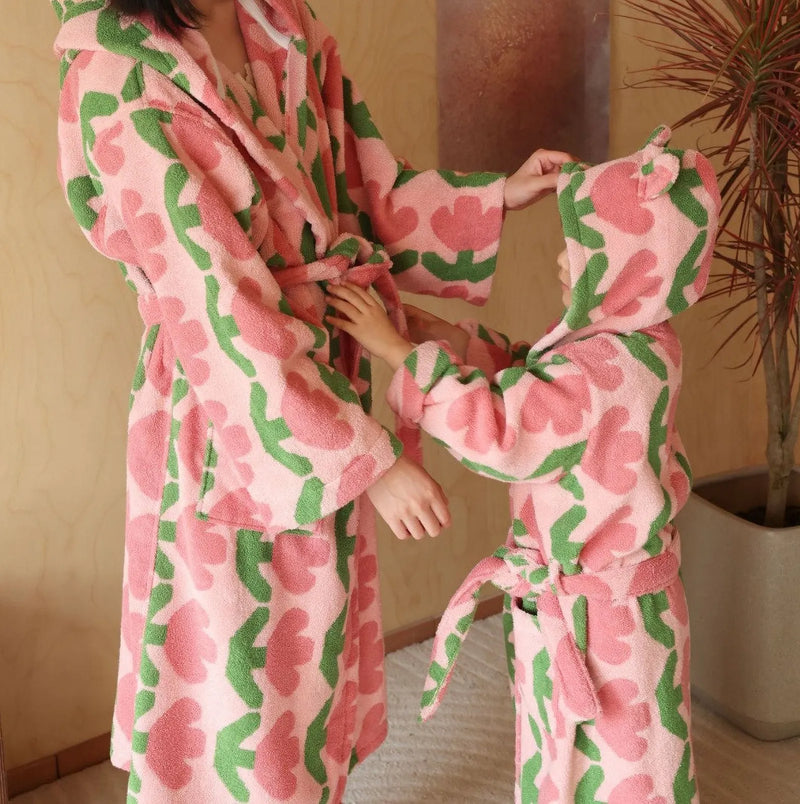 Two people sharing a moment in matching plush pink tulip cotton robes, soft cottagecore morning. — RoomDen