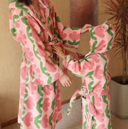 Woman and child sharing a moment wearing matching plush pink tulip cotton robes.