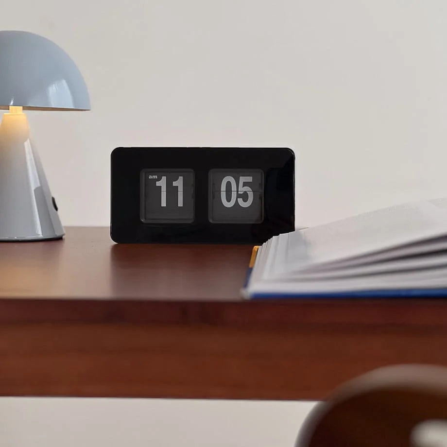 Close-up of the all-black automatic flip clock's numeral display. - RoomDen
