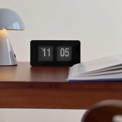 Close-up of the all-black automatic flip clock's numeral display. - RoomDen