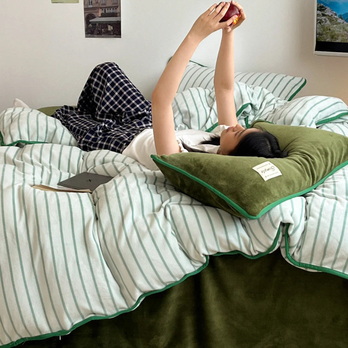 A person lying in the Olive Green Striped Flannel Fleece Bedding Set, showing its cozy texture. - RoomDen