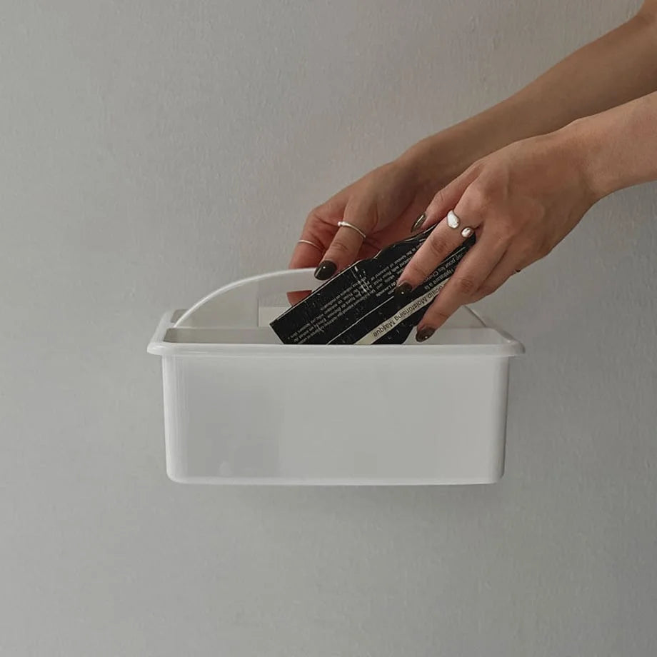 A person placing an item into the white portable organizer caddy. - RoomDen