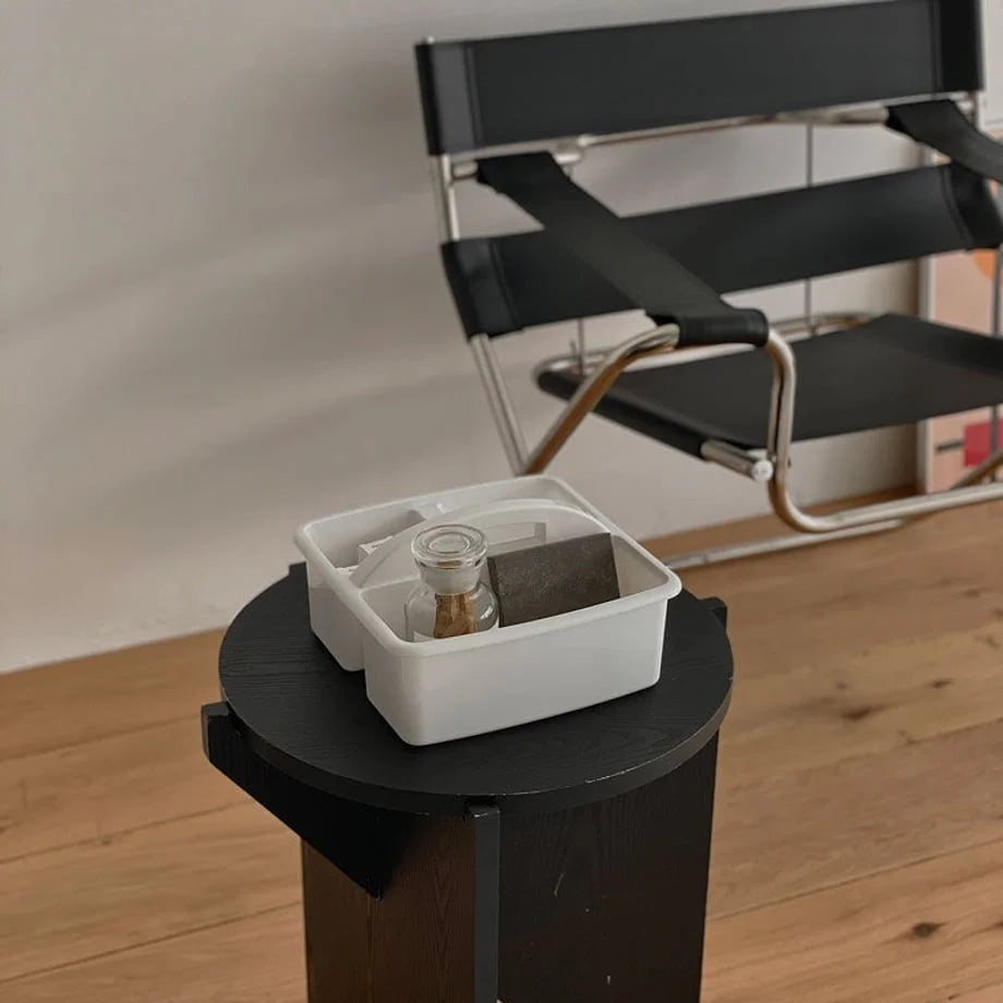 Top-down view of the white organizer caddy with items inside, placed on a black table. - RoomDen