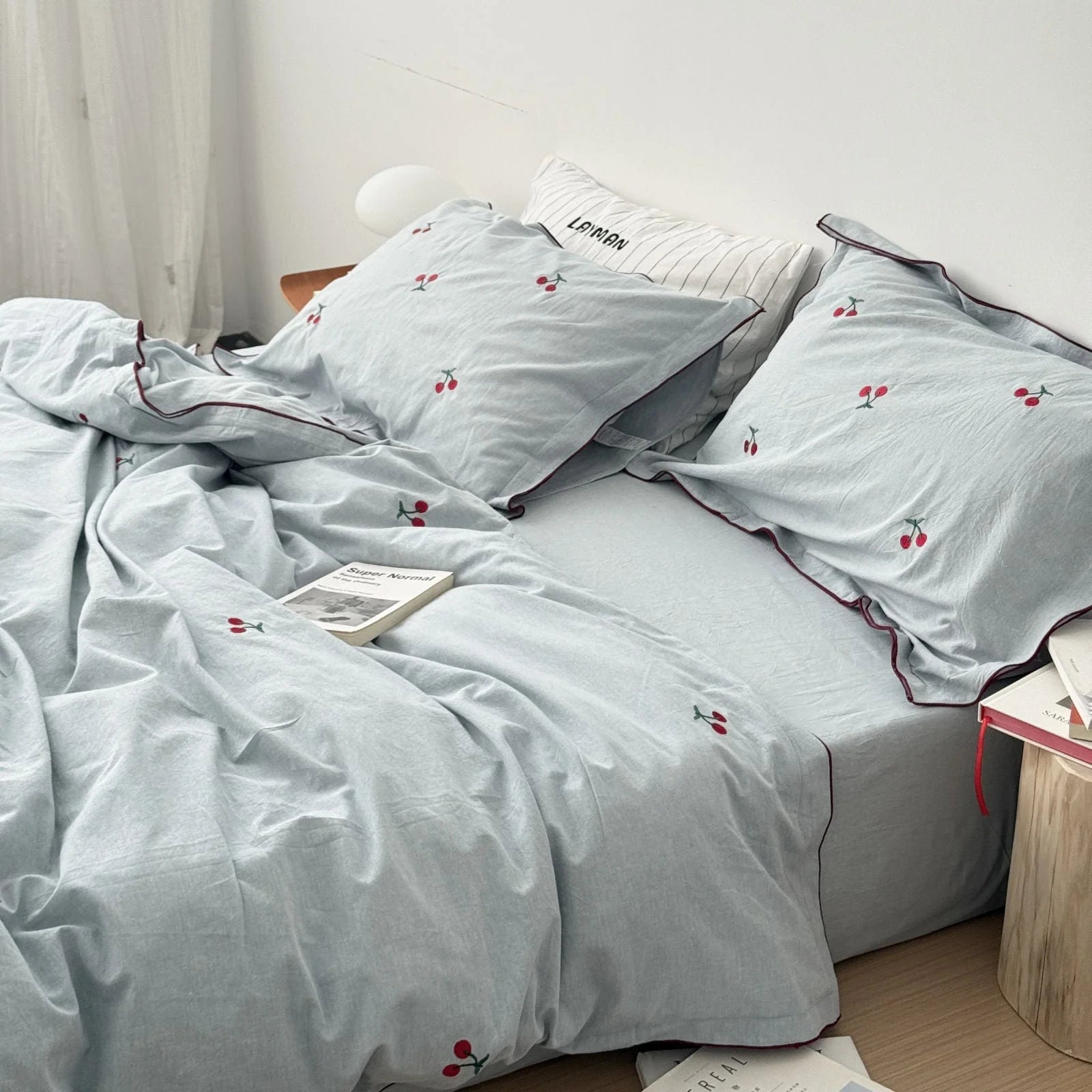 Lifestyle shot of the dusty blue cherry bedding set in a well-lit bedroom, creating a calm atmosphere.
