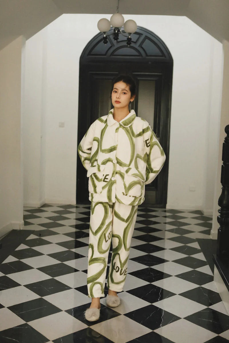 Full-length view of a model in the Plush Graffiti Love Fleece Pajama Set and slippers in a grand hallway - RoomDen.