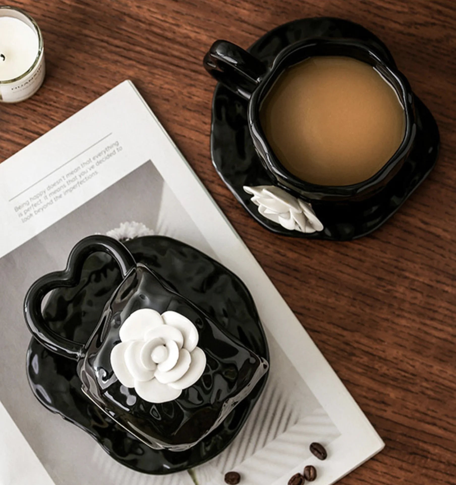 Overhead view of two Black Camellia Mug and Saucer Sets on a wooden table - RoomDen