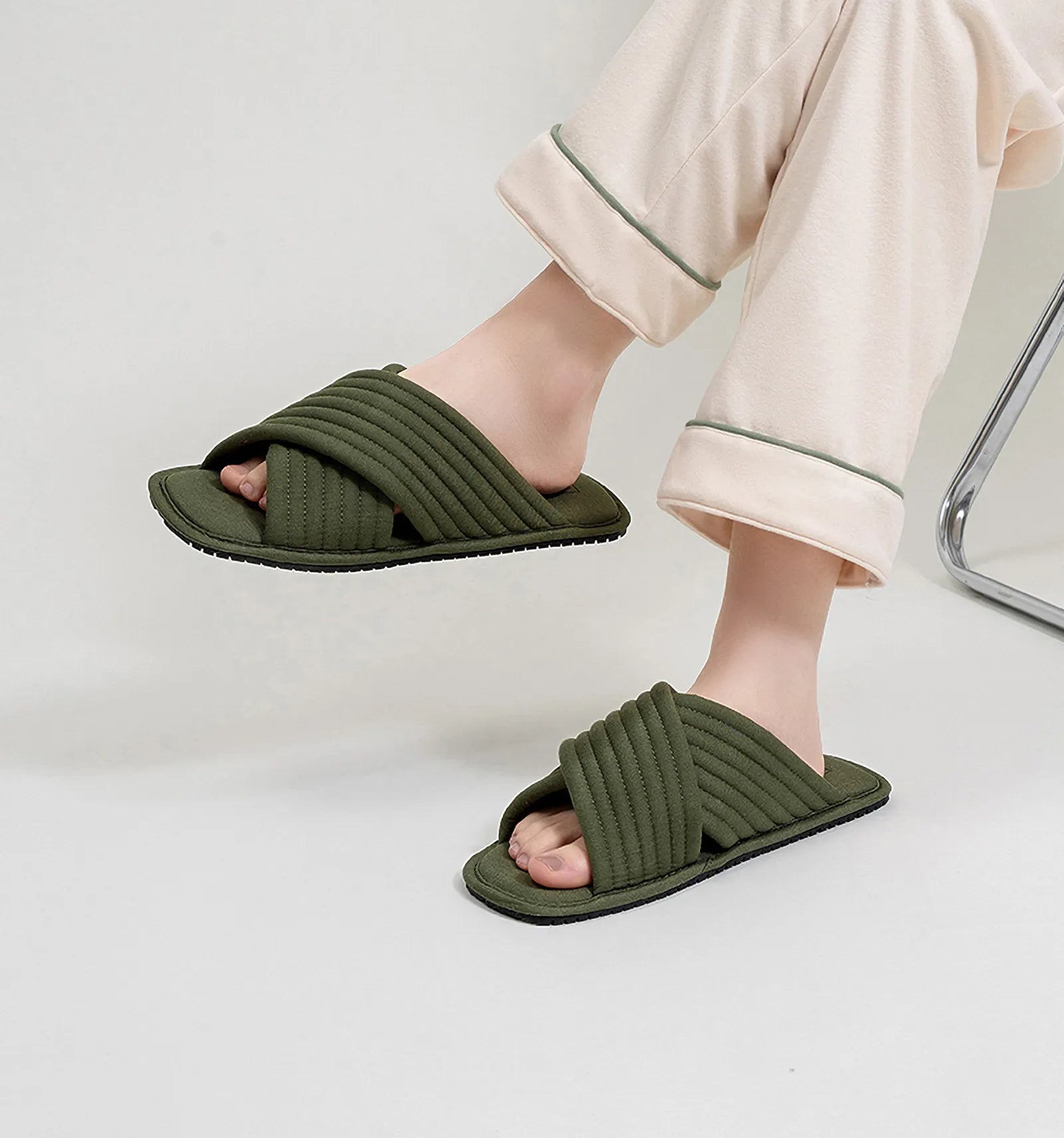 Lifestyle shot of Olive Green quilted slippers worn while sitting