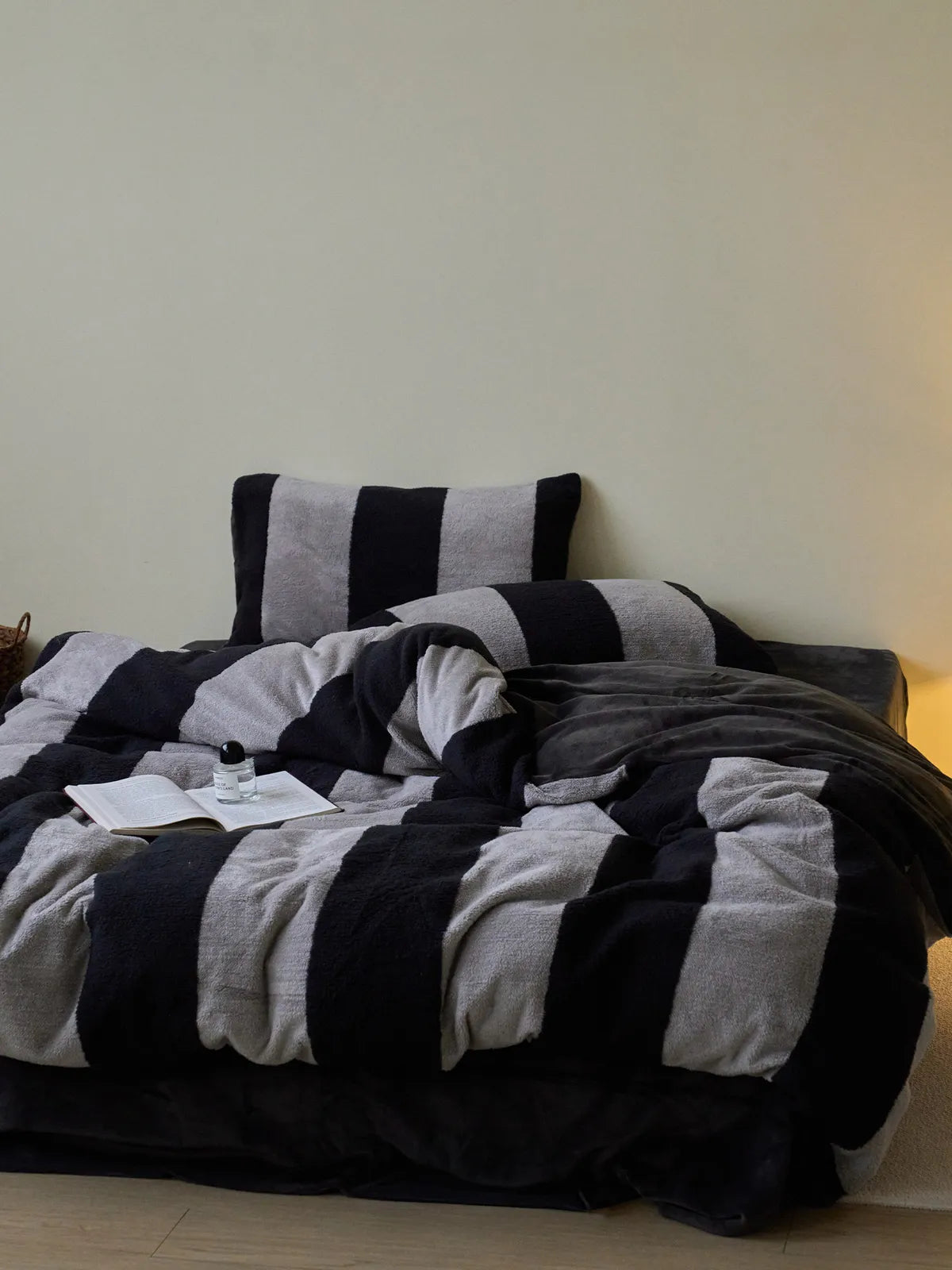 Lifestyle image of the cozy black and grey striped bedding set, looking warm and inviting in soft lighting. - RoomDen