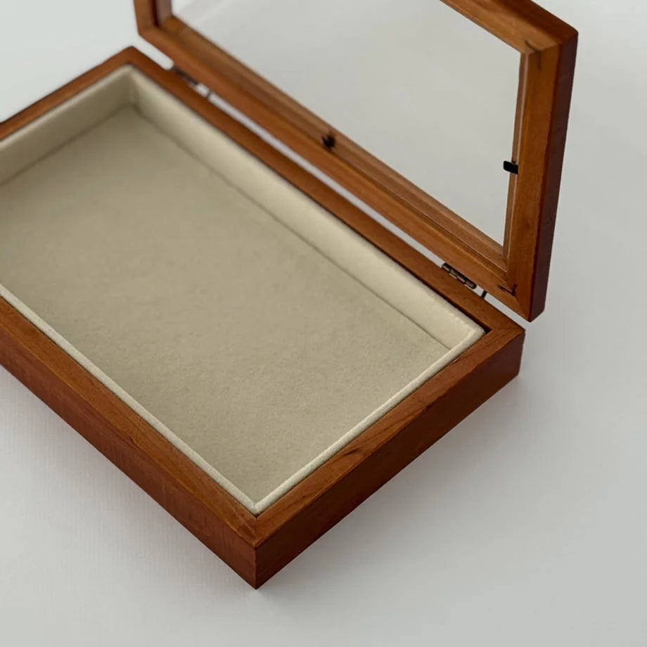 Close-up detail of the corner and soft interior lining of the open wood jewelry box. - RoomDen