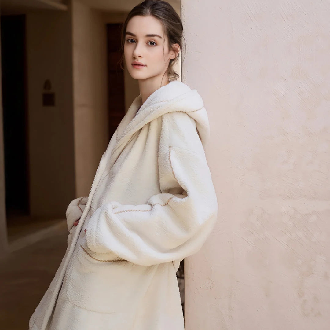Model leaning against a wall, highlighting the relaxed fit of the creamy white hooded pajama jacket - RoomDen.