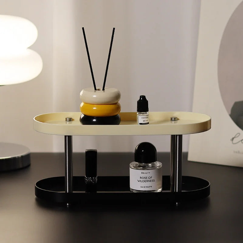 Close-up of a two-tier black and cream vanity tray holding perfume and a diffuser. - RoomDen