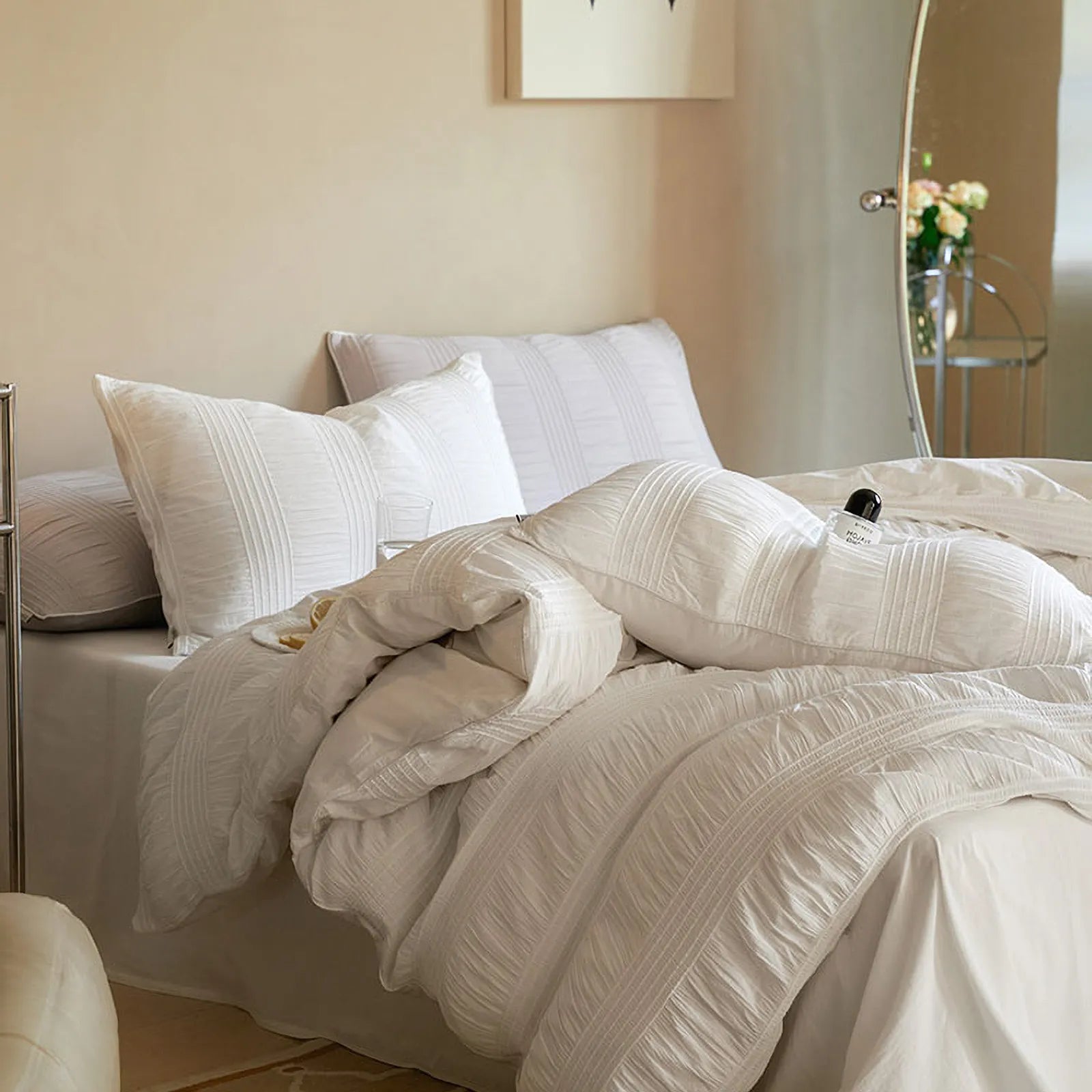 A messy, inviting view of the Classic White pintuck duvet cover, emphasizing its coziness.