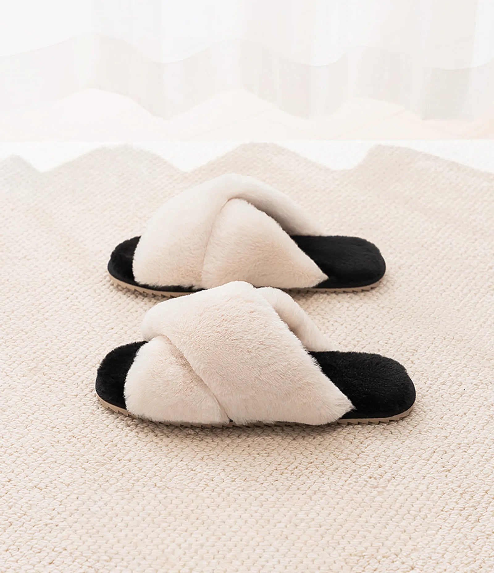Pair of plush White cross-band slippers with black soles on a textured rug - RoomDen