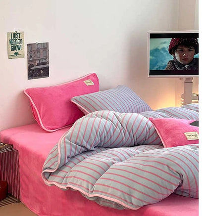 Side view of the Bubblegum Pink striped bedding set in a dorm room setting with a TV. - RoomDen