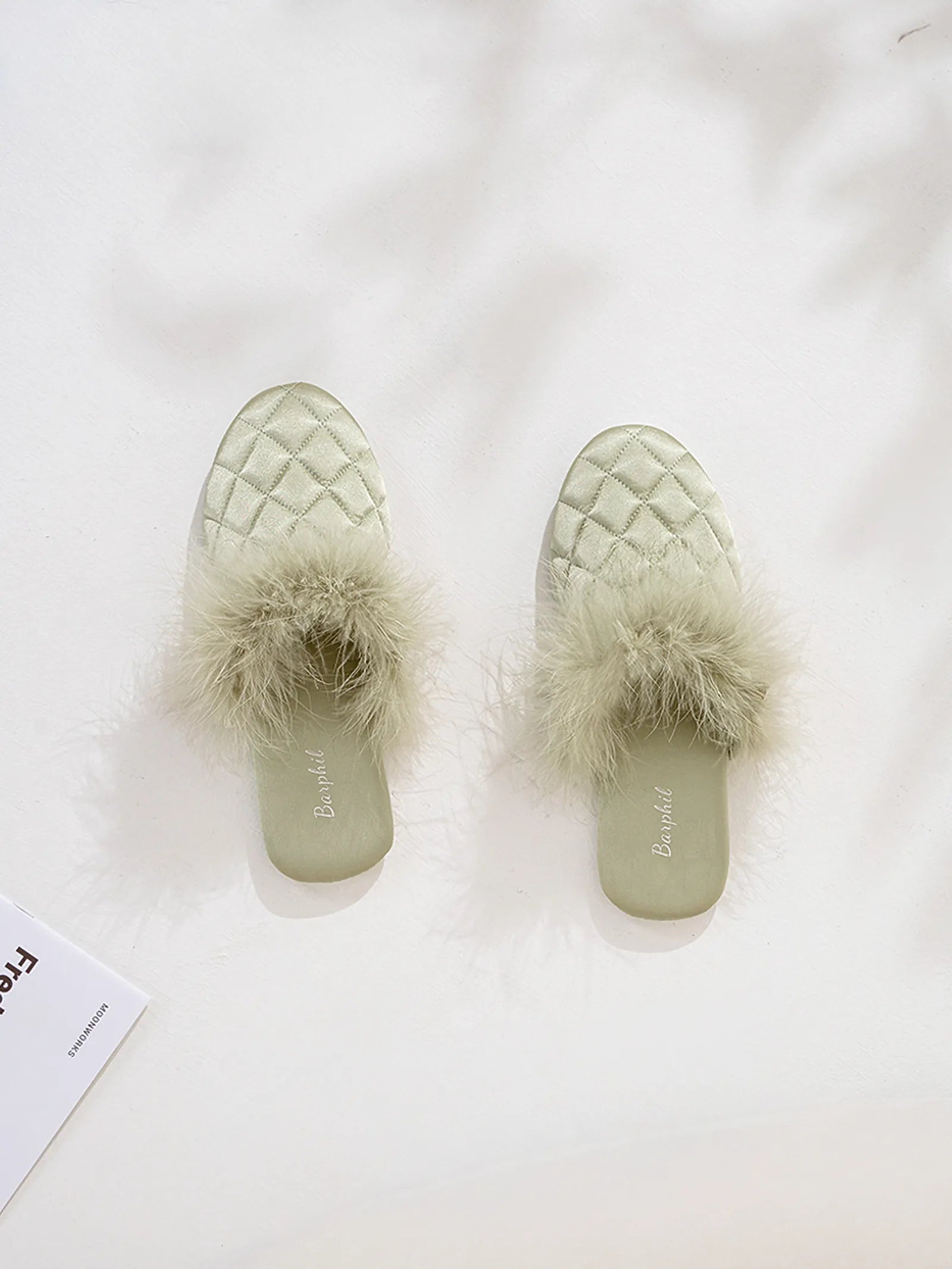Top view of green diamond quilted satin slippers with fluffy upper